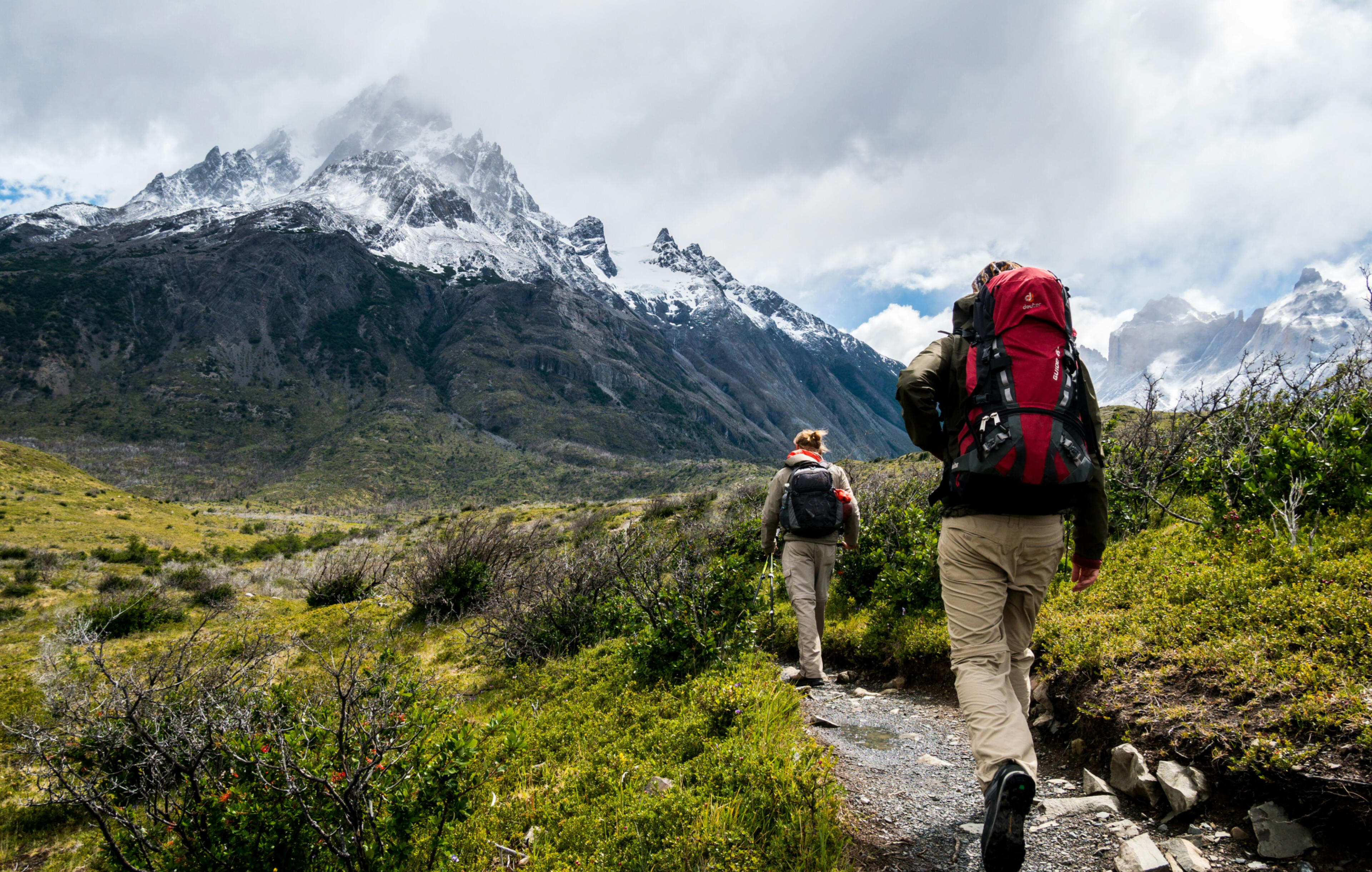 Adventure travelers Two women hiking along the base of snowy mountains